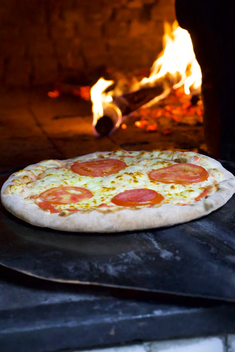 Pizza de mussarela com tomate saindo do forno a lenha da Premiatta